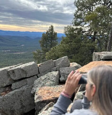 marcie is looking out on a mountain range with binoculars