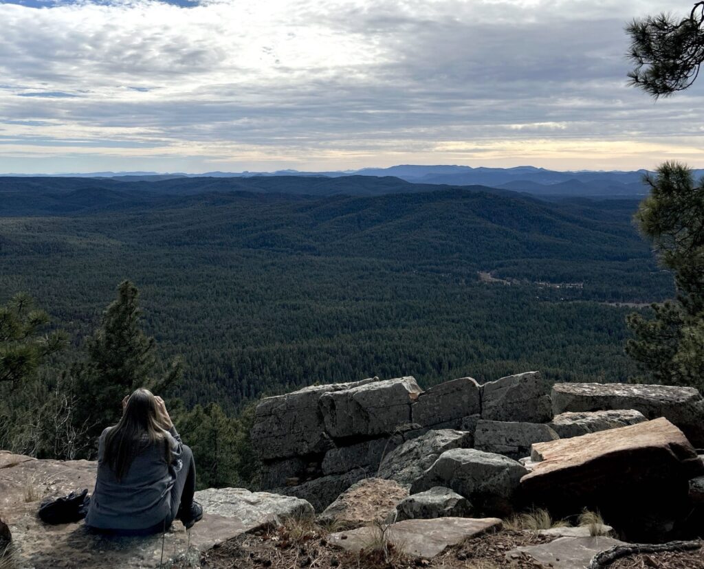 Marcie on an outlook onto mountains